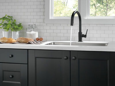 Delta Trinsic in Matte Black installed at kitchen sink with water running